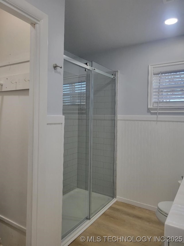 bathroom with wood-type flooring, toilet, and walk in shower