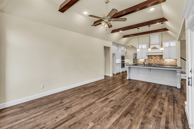 unfurnished living room featuring vaulted ceiling with beams, ceiling fan, sink, and dark wood-type flooring