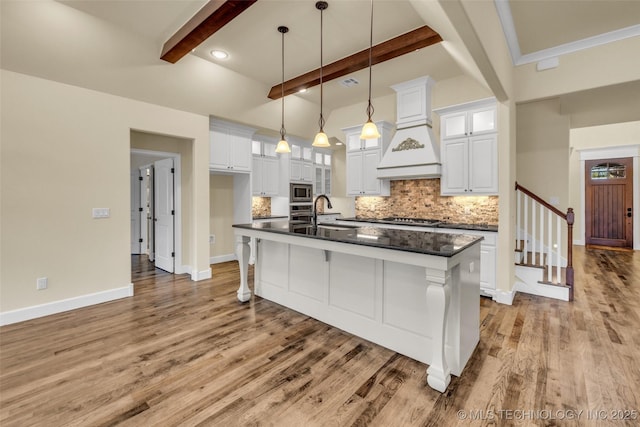 kitchen featuring beam ceiling, white cabinetry, appliances with stainless steel finishes, and sink