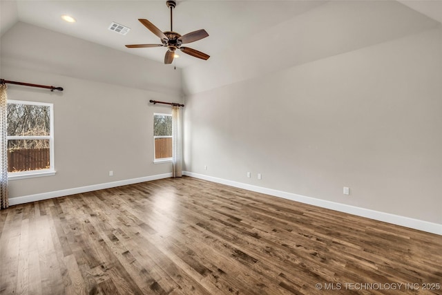 spare room with a healthy amount of sunlight, wood-type flooring, and vaulted ceiling