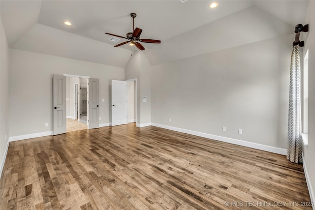 unfurnished bedroom with ceiling fan, light hardwood / wood-style floors, lofted ceiling, and ensuite bath