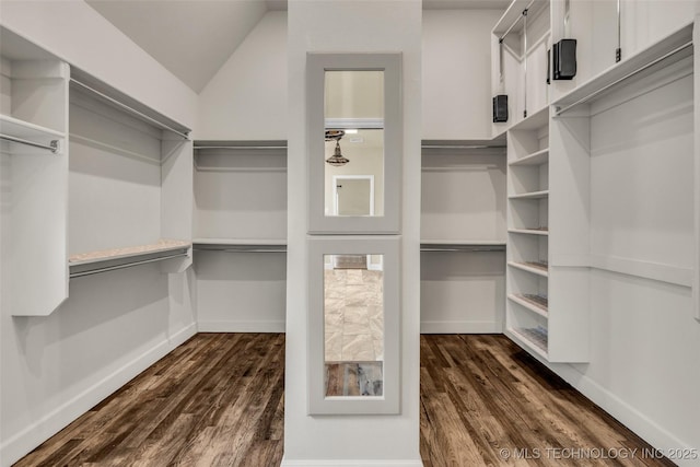 walk in closet featuring dark wood-type flooring and lofted ceiling