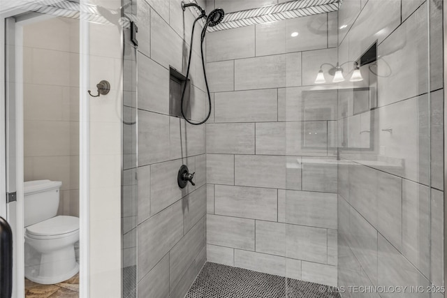 bathroom with toilet and tiled shower