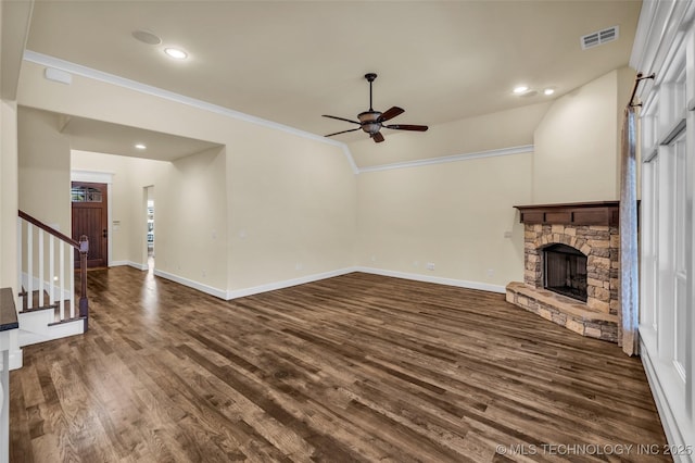 unfurnished living room with ceiling fan, dark hardwood / wood-style flooring, lofted ceiling, a fireplace, and ornamental molding