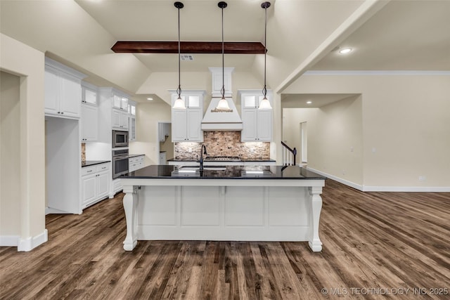 kitchen with backsplash, an island with sink, decorative light fixtures, white cabinetry, and stainless steel appliances