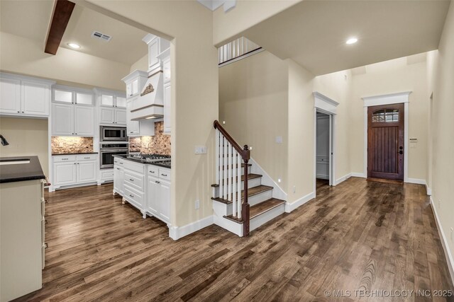 kitchen featuring sink, dark hardwood / wood-style flooring, beamed ceiling, white cabinets, and appliances with stainless steel finishes