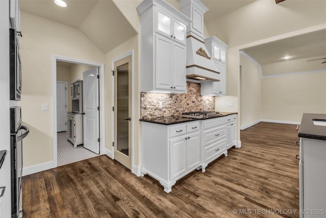 kitchen featuring white cabinetry, stainless steel gas cooktop, dark hardwood / wood-style flooring, backsplash, and custom range hood