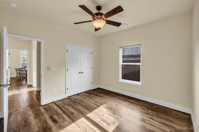 unfurnished bedroom featuring ceiling fan, a closet, and wood-type flooring