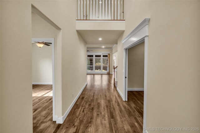 corridor featuring a towering ceiling and hardwood / wood-style flooring