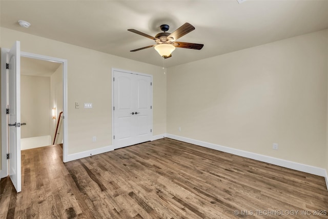 unfurnished bedroom featuring hardwood / wood-style floors, a closet, and ceiling fan