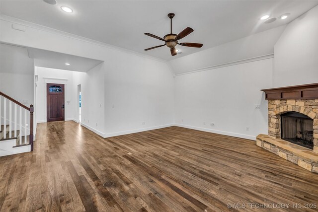 12050 S 68th E Ave E, Bixby, OK 74008 - unfurnished living room featuring ceiling fan, stairs, dark wood finished floors, a stone fireplace, and crown molding