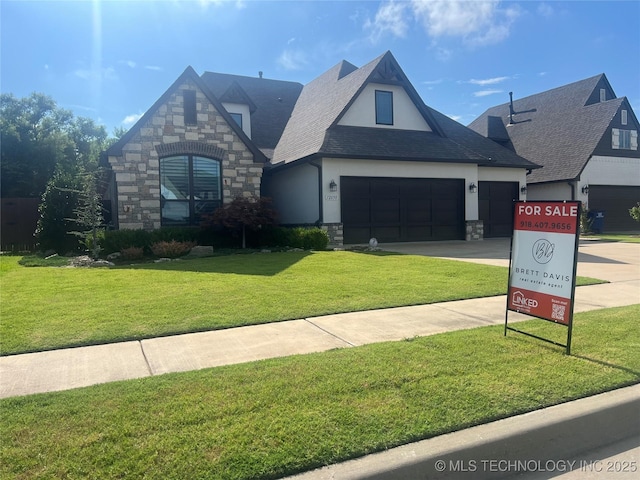 12050 S 68th E Ave E, Bixby, OK 74008 - view of front of home featuring stone siding, a front yard, stucco siding, an attached garage, and concrete driveway