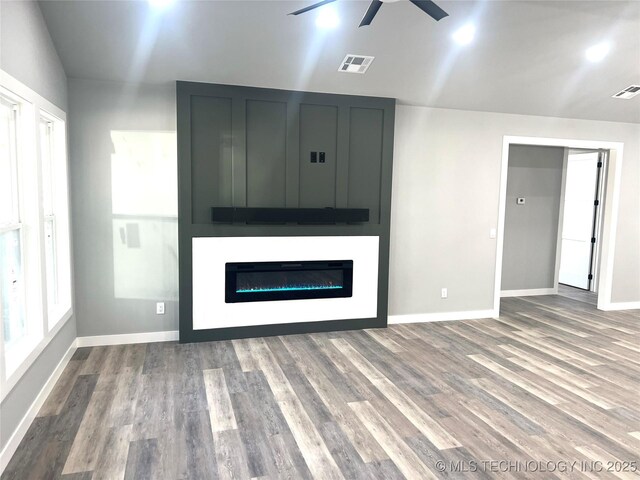 unfurnished living room with hardwood / wood-style flooring and ceiling fan