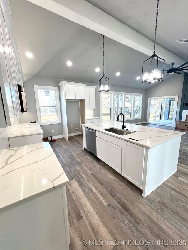 kitchen with white cabinets, stainless steel dishwasher, a kitchen island with sink, and sink