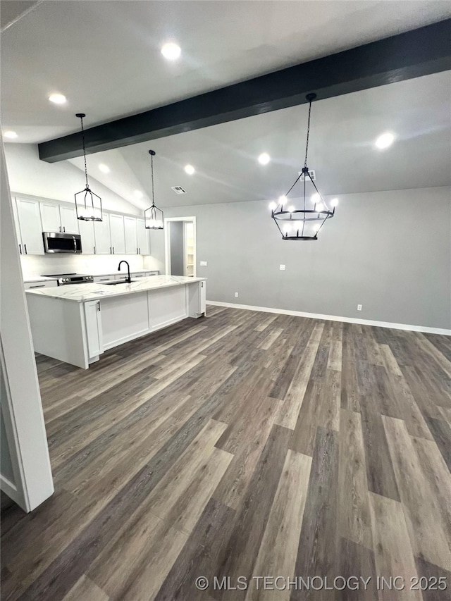 kitchen with appliances with stainless steel finishes, sink, pendant lighting, lofted ceiling with beams, and white cabinets