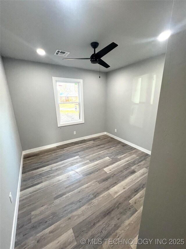 spare room with ceiling fan and dark hardwood / wood-style flooring