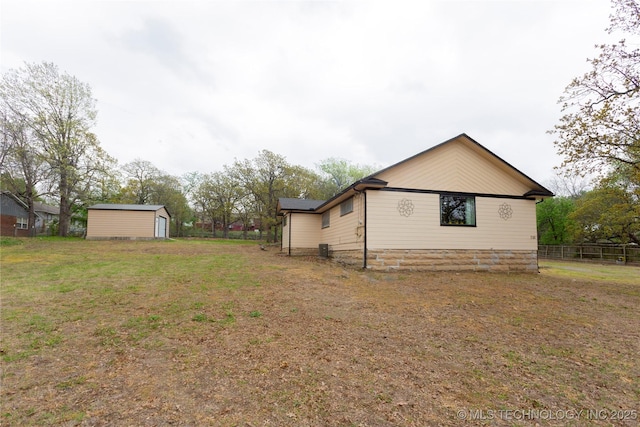 view of home's exterior with a yard and an outdoor structure