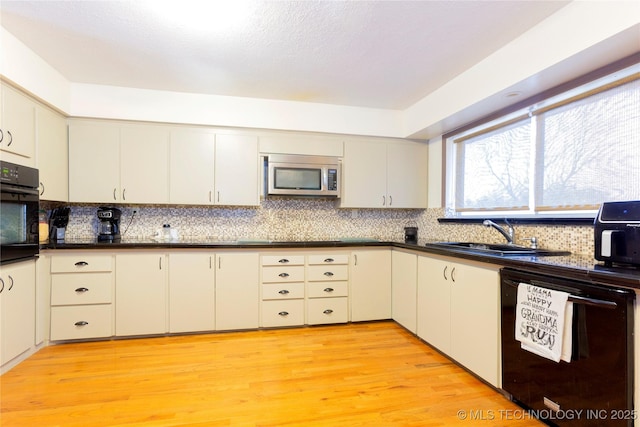 kitchen featuring light wood-type flooring, sink, and black appliances