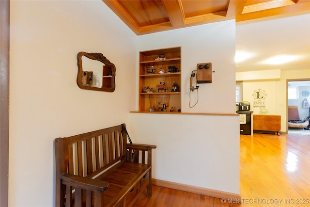 hall featuring beam ceiling, hardwood / wood-style flooring, coffered ceiling, and wood ceiling