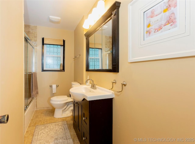 full bathroom featuring shower / bath combination with glass door, vanity, tile patterned floors, and toilet