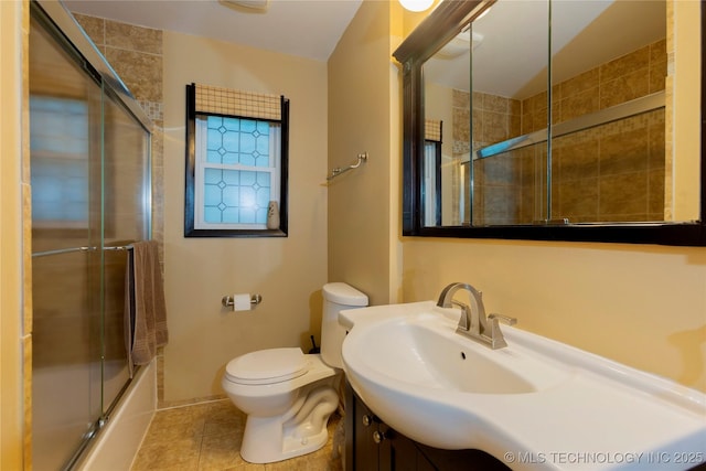 full bathroom featuring tile patterned flooring, vanity, combined bath / shower with glass door, and toilet