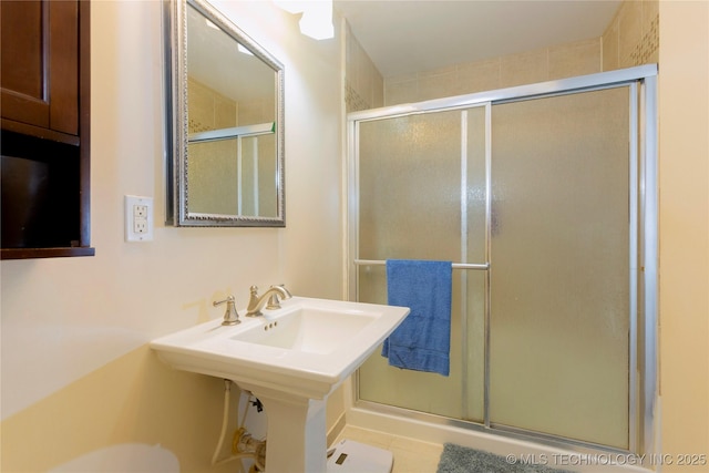 bathroom with tile patterned flooring and a shower with shower door