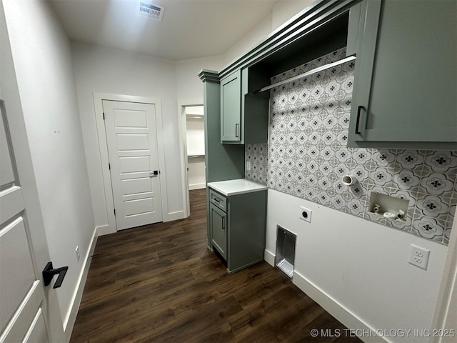 laundry area with hookup for an electric dryer, dark hardwood / wood-style flooring, and cabinets