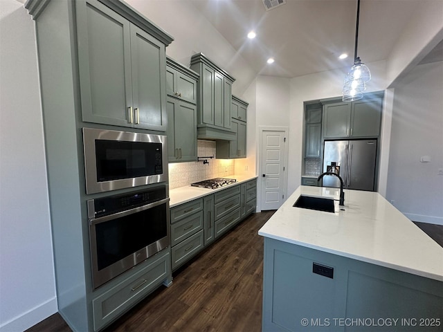 kitchen featuring backsplash, sink, hanging light fixtures, dark hardwood / wood-style floors, and stainless steel appliances