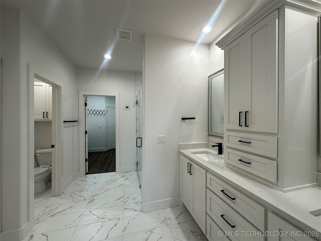 bathroom with vanity, a shower with shower door, and toilet