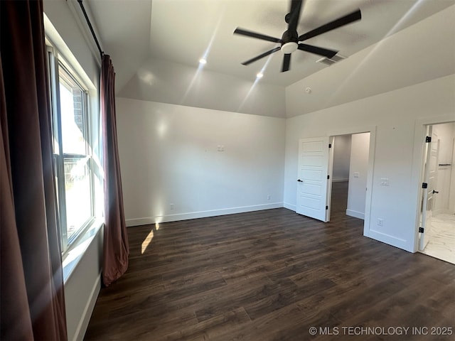 unfurnished bedroom with dark hardwood / wood-style flooring, a tray ceiling, ceiling fan, and ensuite bathroom