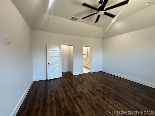 unfurnished bedroom featuring ceiling fan, lofted ceiling, dark wood-type flooring, and ensuite bath