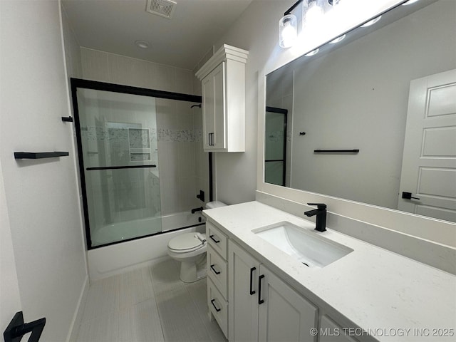 full bathroom featuring tile patterned flooring, vanity, toilet, and bath / shower combo with glass door