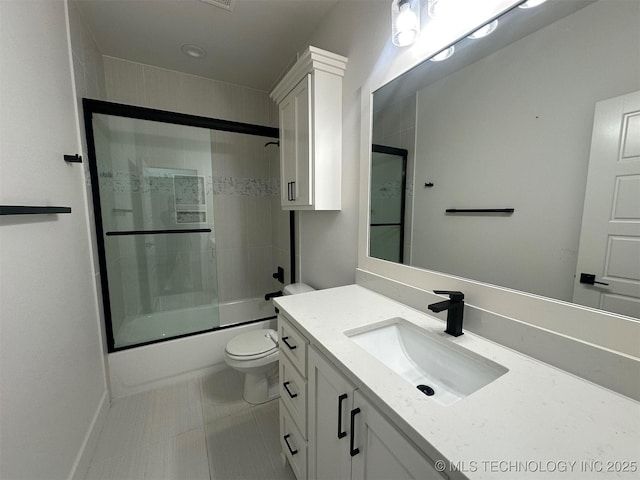 full bathroom with tile patterned flooring, vanity, toilet, and bath / shower combo with glass door