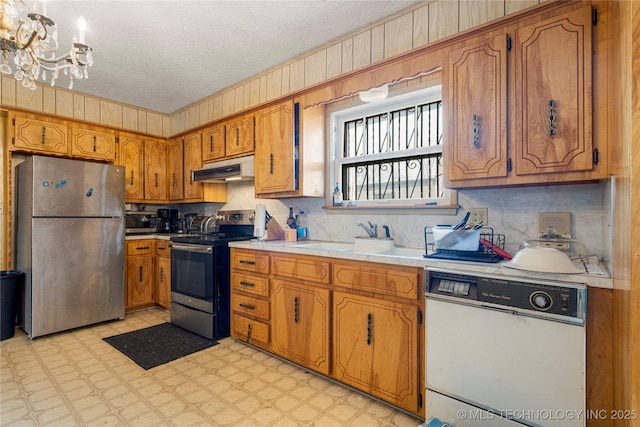 kitchen featuring a chandelier, sink, stainless steel appliances, and a textured ceiling