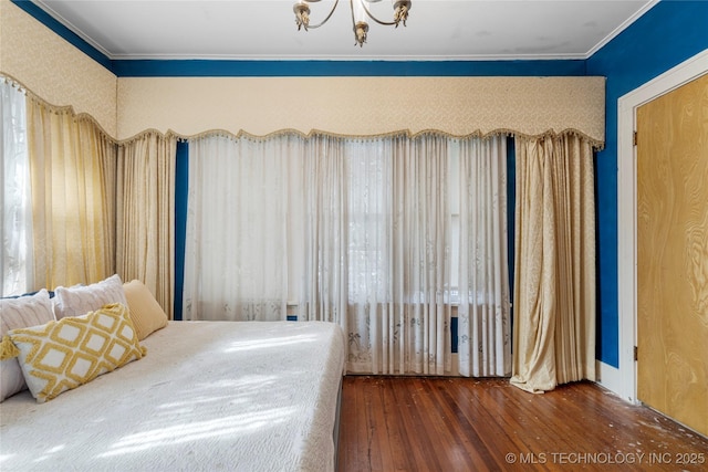 bedroom with dark hardwood / wood-style flooring and a chandelier