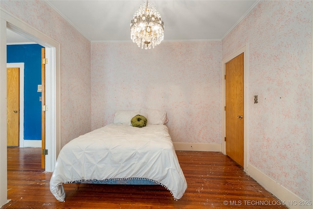 bedroom featuring hardwood / wood-style floors, a notable chandelier, and crown molding