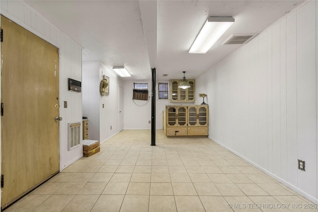 basement with wood walls and light tile patterned floors