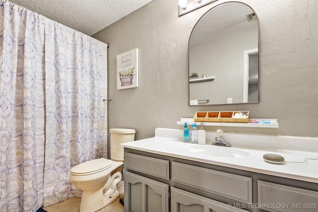 bathroom featuring tile patterned flooring, vanity, a textured ceiling, and toilet