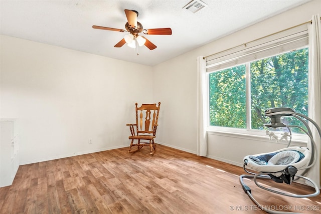 sitting room featuring light wood-type flooring and ceiling fan