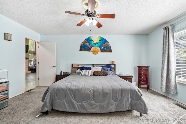 bedroom featuring carpet flooring, a textured ceiling, and ceiling fan