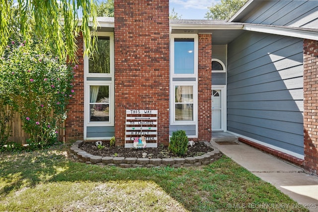 property entrance featuring a lawn