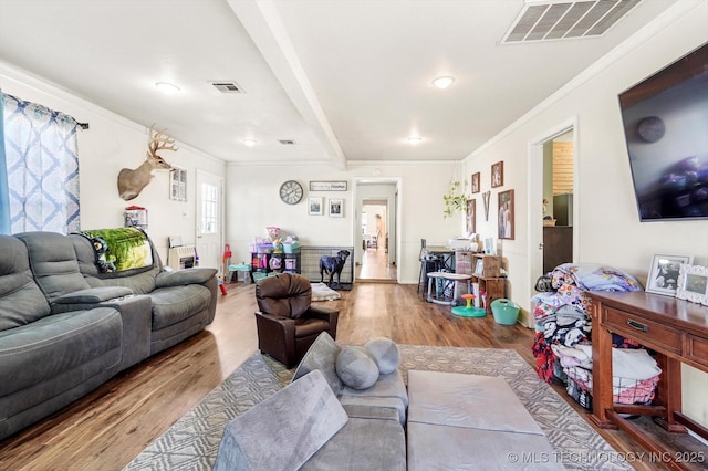 living room with beam ceiling, crown molding, and hardwood / wood-style floors