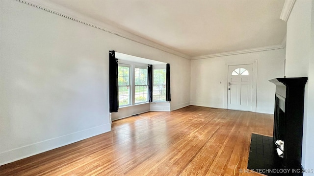 entryway with crown molding and light hardwood / wood-style floors