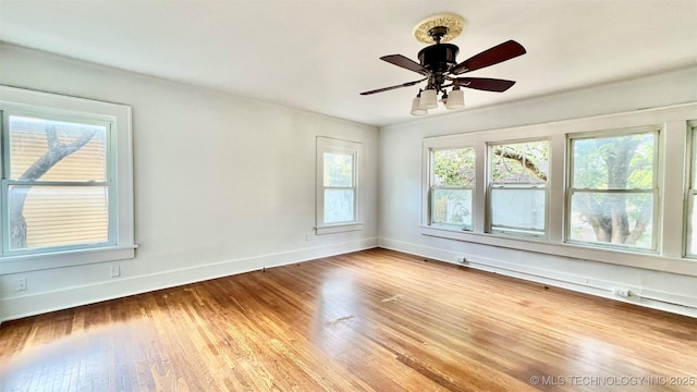 empty room with hardwood / wood-style floors and ceiling fan