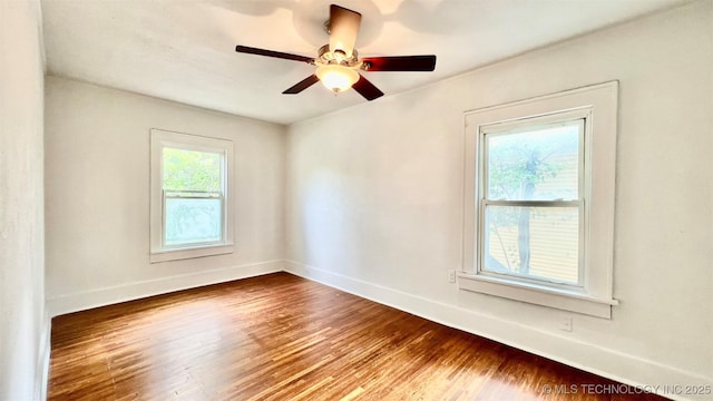 empty room featuring ceiling fan, plenty of natural light, and wood-type flooring