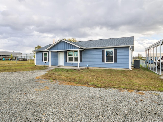 view of front of house with a front lawn, central AC unit, and a carport