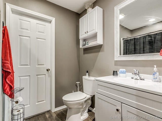 bathroom featuring curtained shower, vanity, wood-type flooring, and toilet