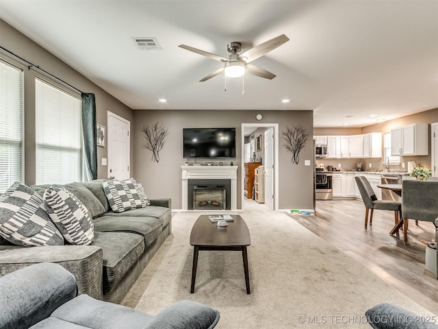 living room with ceiling fan and sink