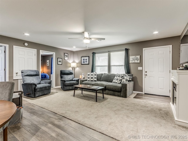 living room with ceiling fan and light wood-type flooring