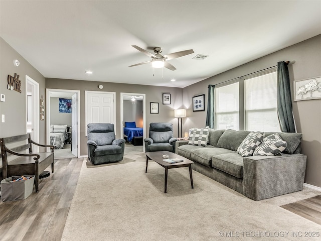 living room with light hardwood / wood-style floors and ceiling fan